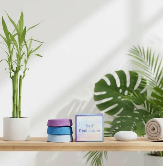 Lumaysa Self Realisation chakra bath fizz gift set styled on a wooden shelf with green plants and spa decor, creating a calm wellness atmosphere