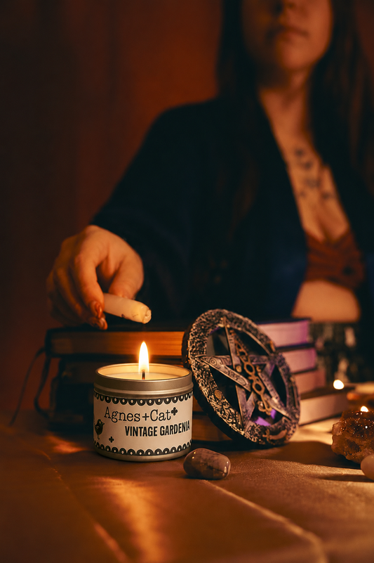 Lit Agnes + Cat Vintage Gardenia soy candle in a cozy spiritual ritual scene with crystals, stacked books, and warm candlelight.