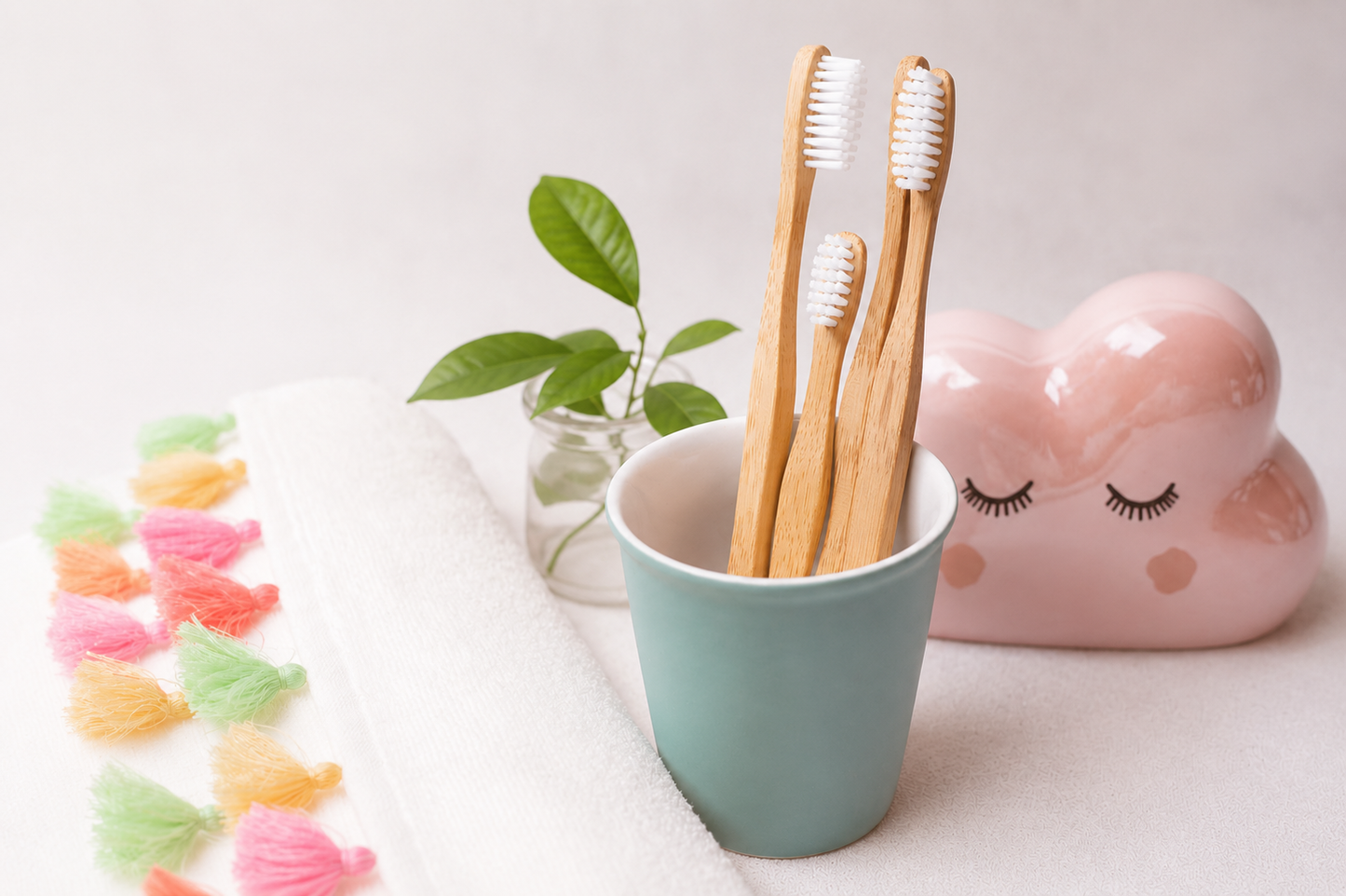 Set of wooden toothbrushes in a teal cup with decorative elements on a light surface.