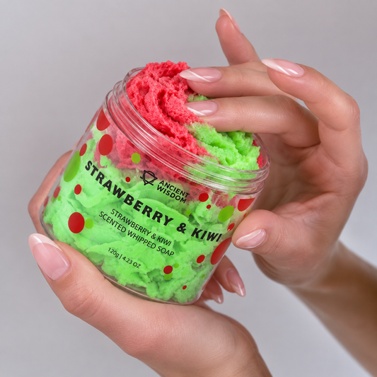 Hands holding an open jar of red and green Strawberry & Kiwi Scented Whipped Soap.