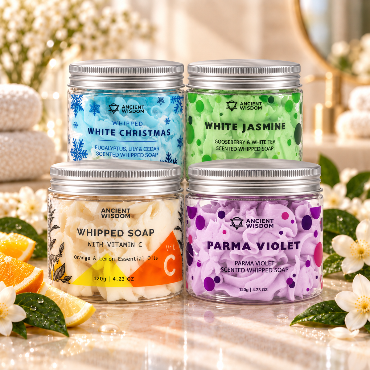 Vitamin C, White Christmas, White Jasmine and Parma Violet whipped soaps displayed in an elegant luxury spa setting.