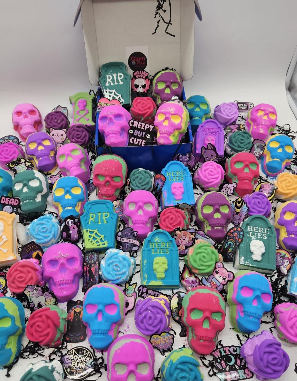 Halloween bath bombs collection featuring colorful skull-shaped and tombstone bath bombs in vibrant neon colors, perfect for spooky self-care gifts
