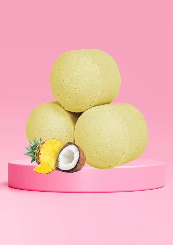 Lumaysa Pina Colada bath bomb chill pills styled on pink background with pineapple and coconut, tropical spa-inspired vegan bath bombs