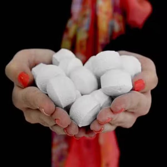 Hands holding white bath bomb chill pills, showcasing mini vegan fizzers for relaxing bath rituals by Lumaysa.