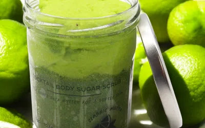 Lumaysa Mint Bliss Mojito Sugar Body Scrub in a glass jar with fresh lime background – green citrus exfoliating scrub.