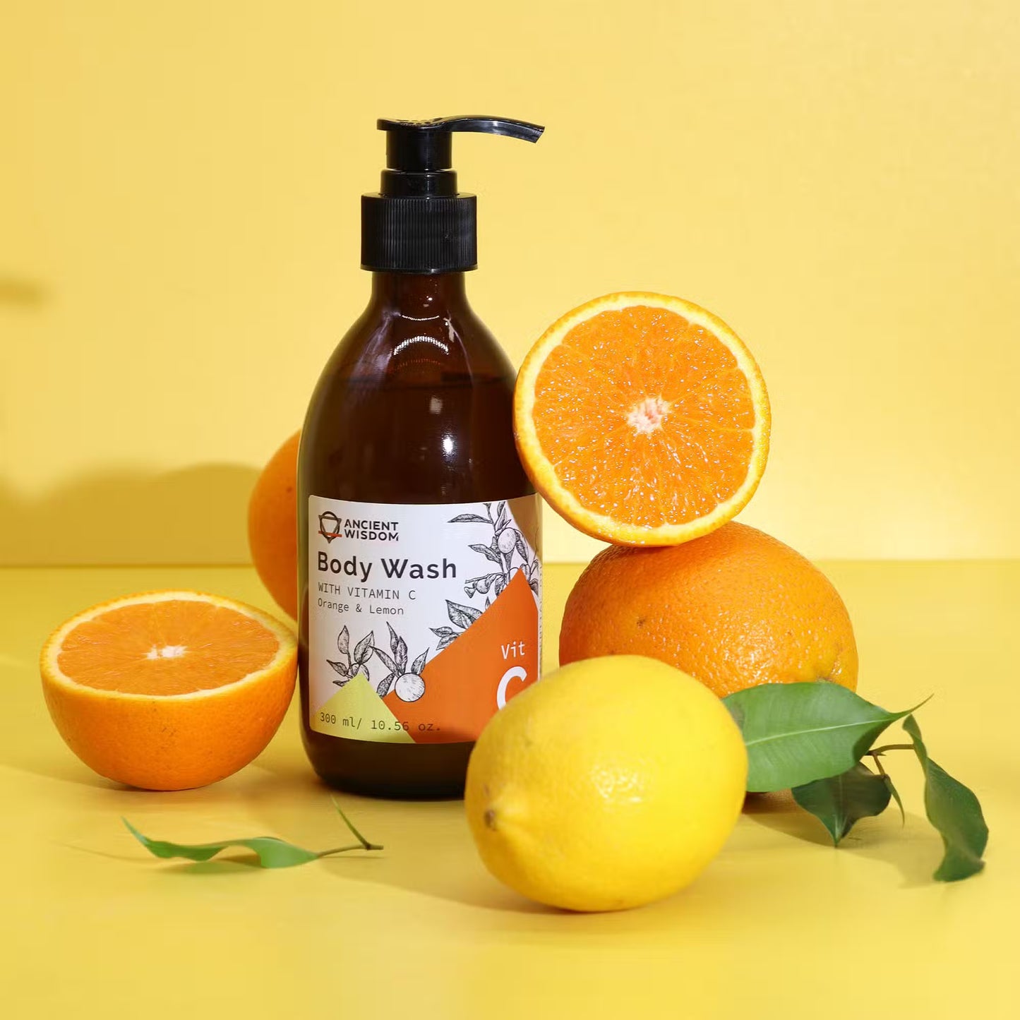 Lumaysa Vitamin C citrus body wash with orange and lemon fruits on a bright yellow background