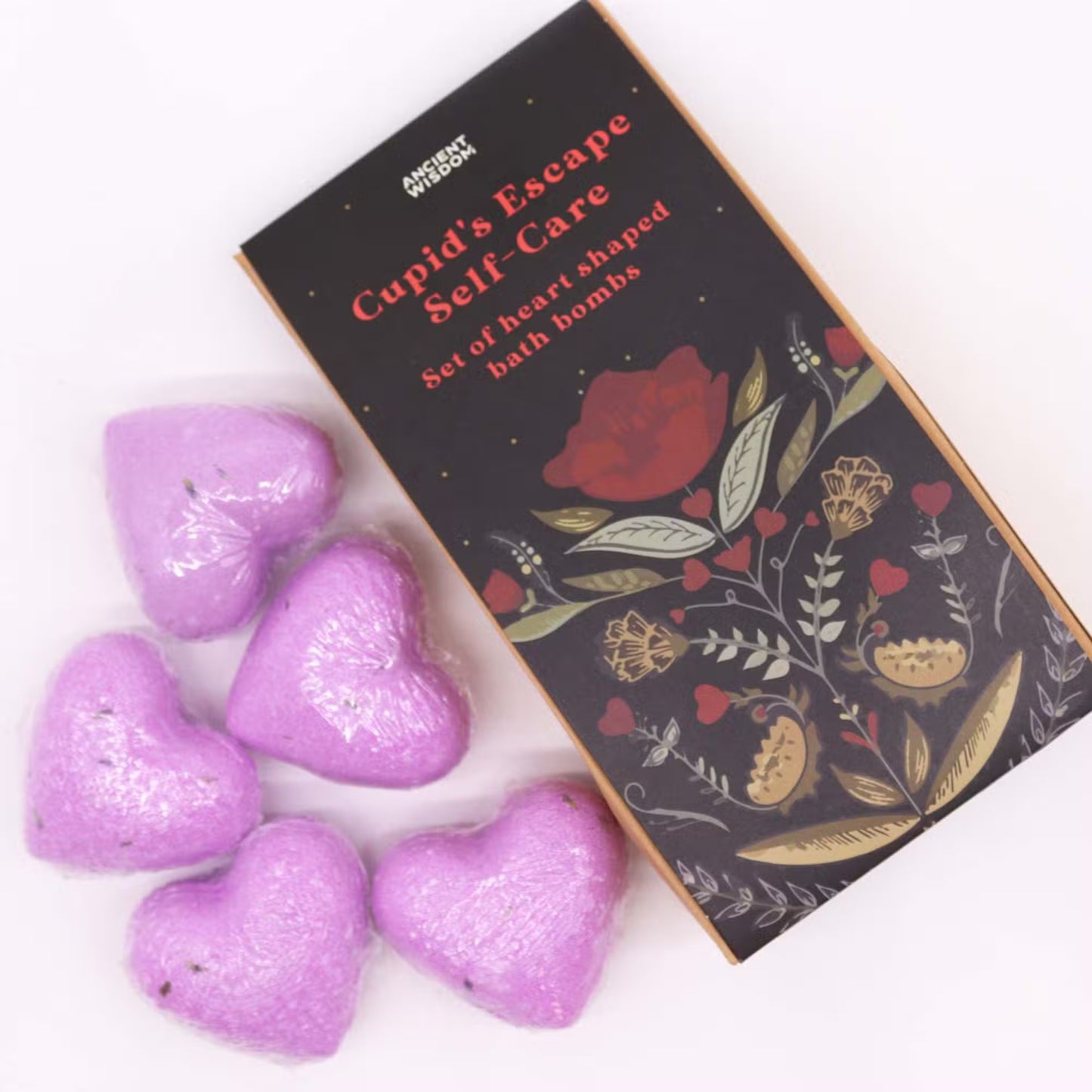 Purple heart-shaped lavender bath bombs arranged beside Lumaysa Purple Serenity floral gift box for a romantic self-care and gifting concept