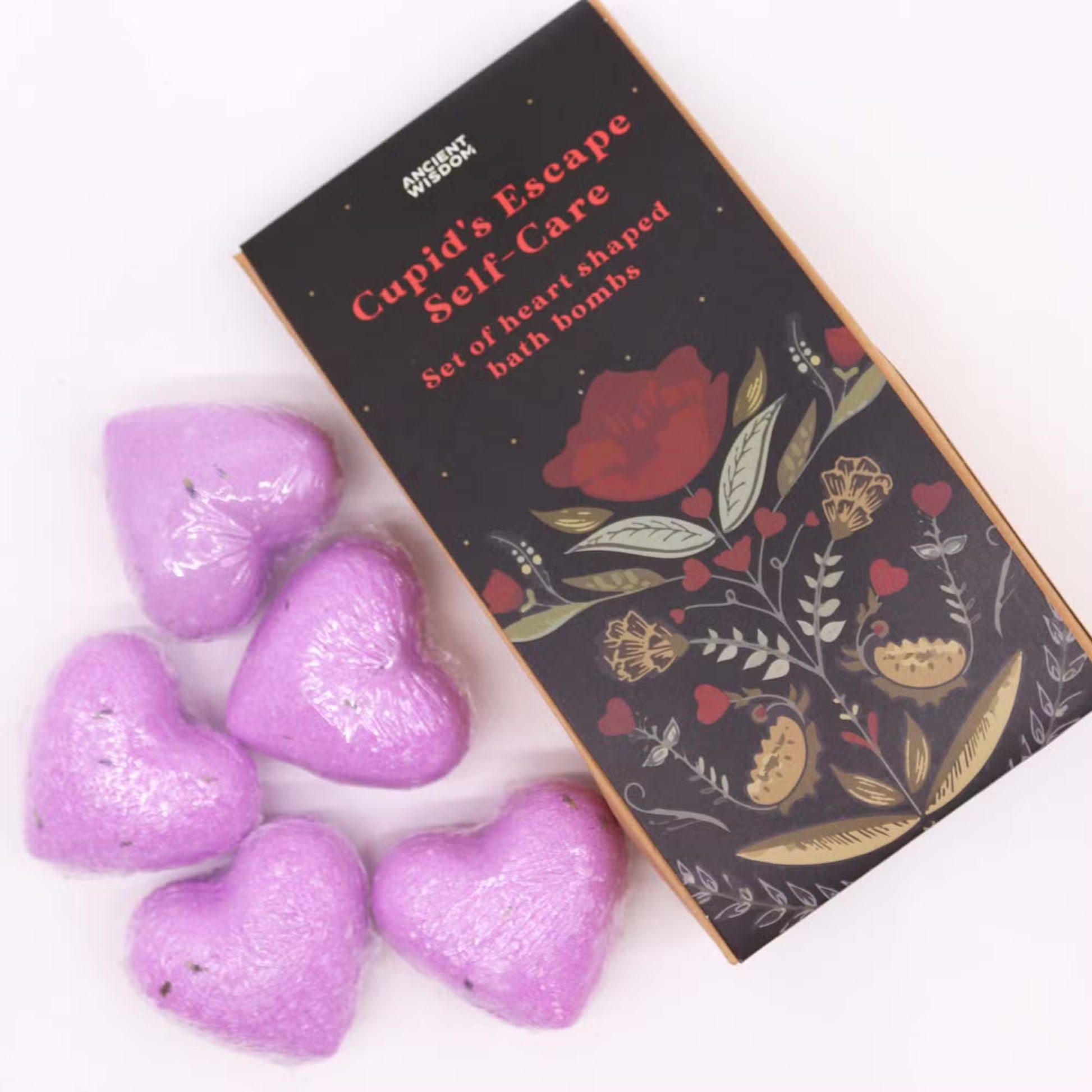 Purple heart-shaped lavender bath bombs arranged beside Lumaysa Purple Serenity floral gift box for a romantic self-care and gifting concept