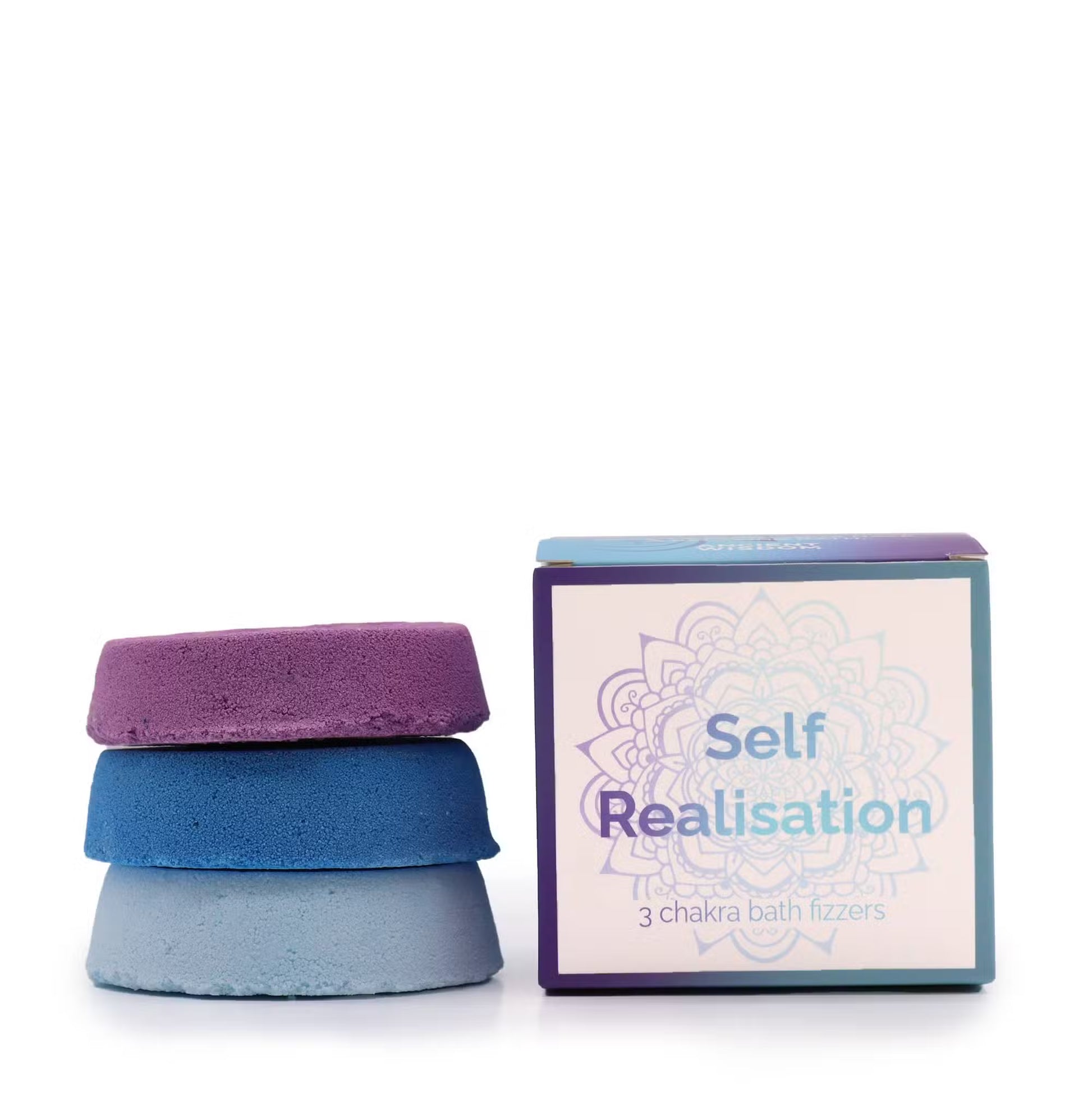 Three stacked chakra bath fizzers in purple, blue and light blue beside Lumaysa Self Realisation mandala gift box on white background