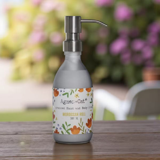 Lumaysa Moroccan Bliss Hand & Body Lotion 300ml in a matte grey pump bottle, styled on a rustic wooden surface with a soft, blurred outdoor background.