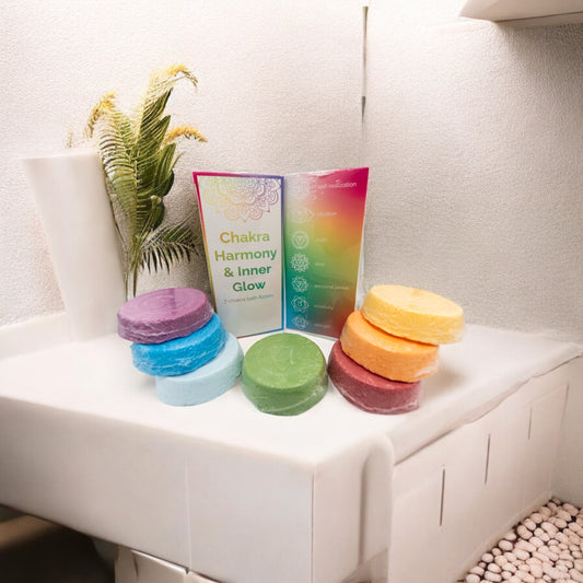 Chakra bath fizzers arranged in a calm spa-inspired bathroom setting with plants and natural light, creating a relaxing self-care and wellness atmosphere.