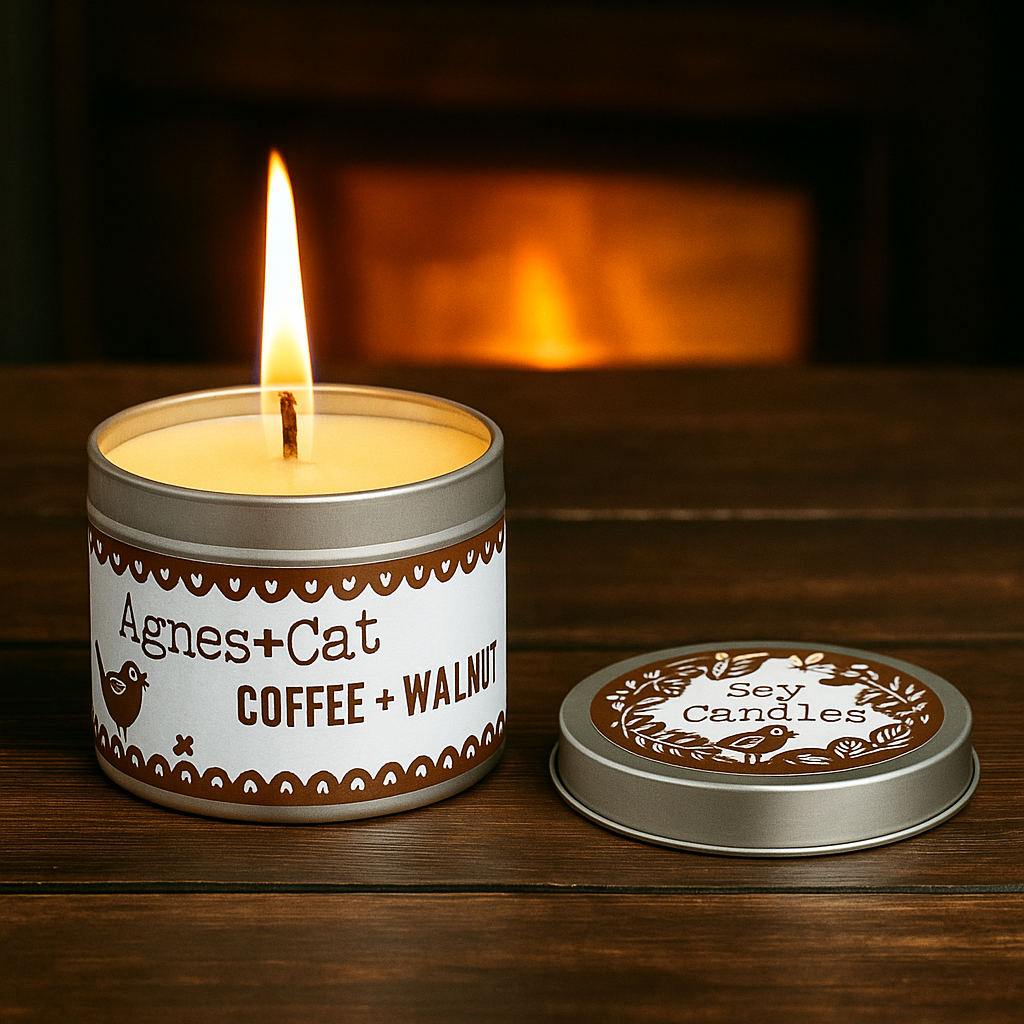 Lit Coffee & Walnut soy candle in reusable tin by Lumaysa, creating a warm cosy café atmosphere with soft amber light.
