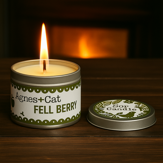 Lumaysa Fell Berry fruity soy candle lit in reusable tin with warm ambient light and green berry label