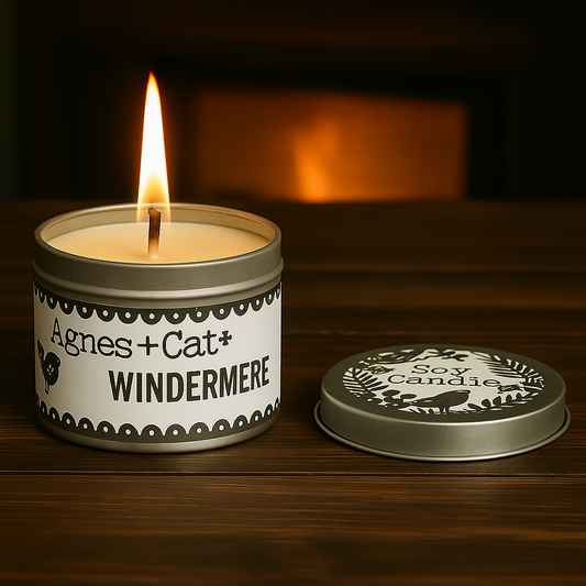 Lumaysa Windermere fresh soy candle by Agnes + Cat, lit candle in silver tin on wooden table with soft warm background glow.