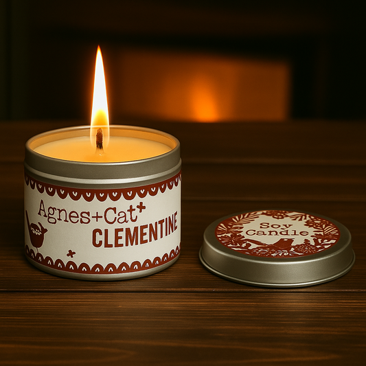Lumaysa Clementine zesty soy candle lit in silver tin with clementine label and soft warm glow