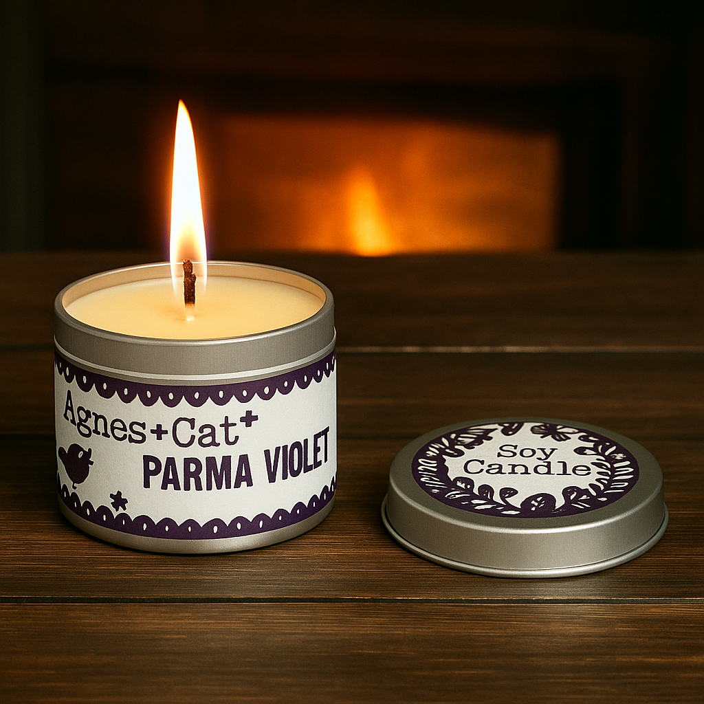 Lumaysa Violet Whisper Parma Violet soy candle in tin with warm flame on wooden surface
