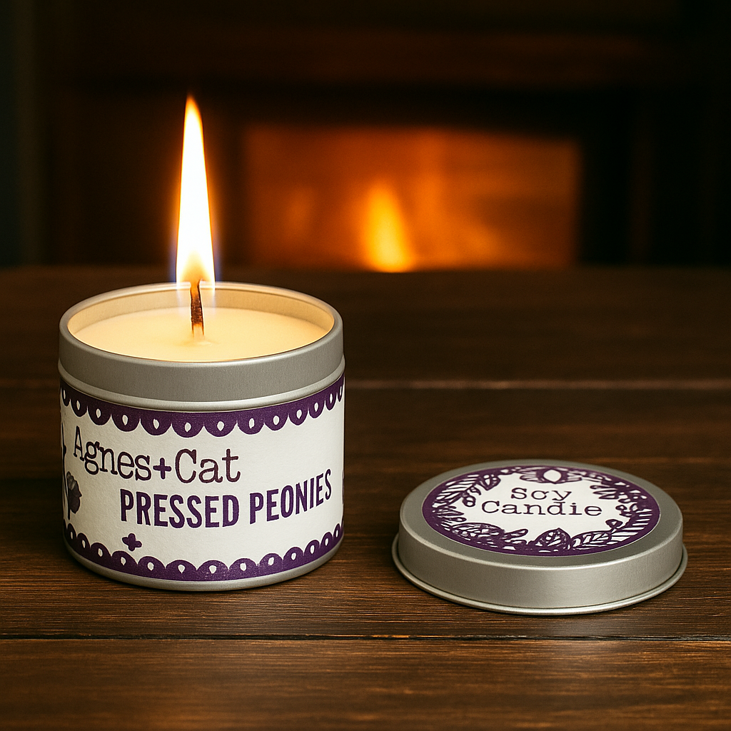 Pressed Peonies soy candle in tin by Lumaysa, lit candle on wooden surface with warm cozy background