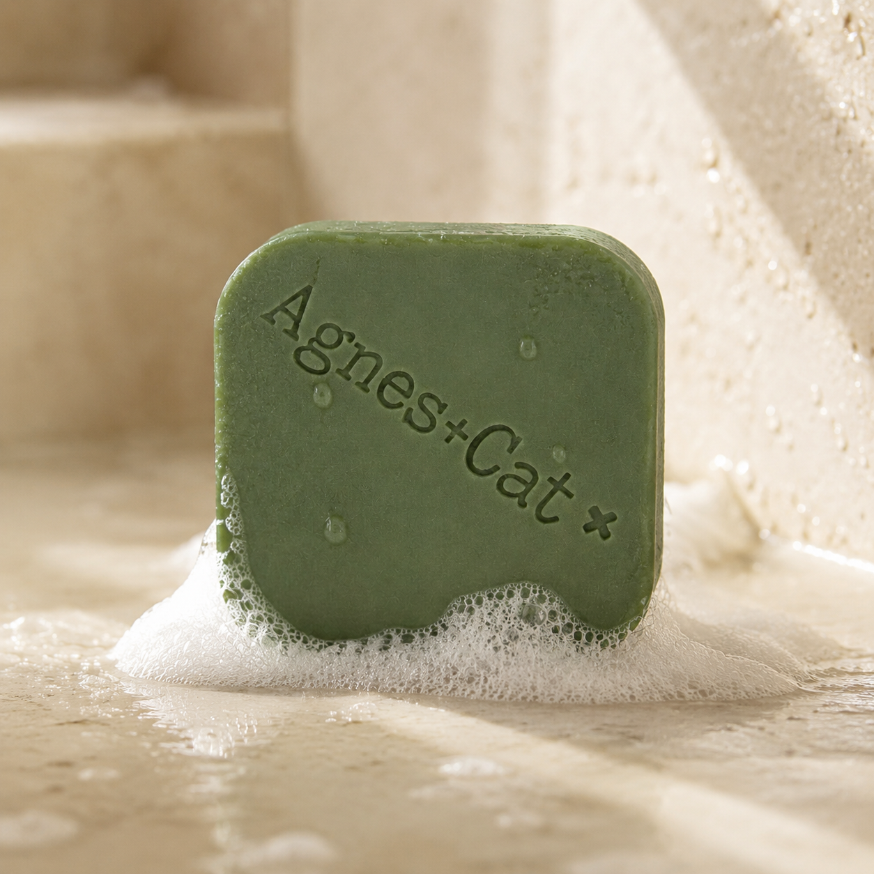 White Fig solid shampoo bar with natural foam and water droplets in a stone shower