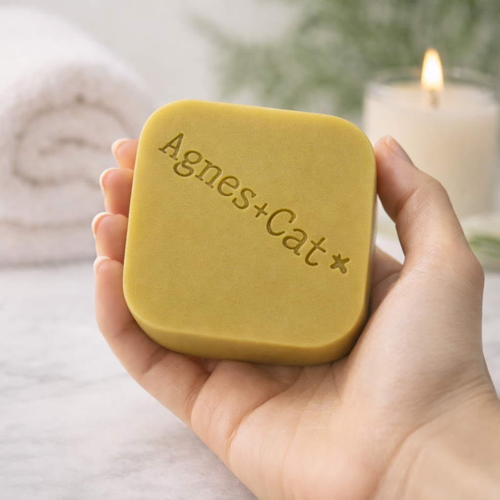 Hand holding Lumaysa Moroccan Roll solid shampoo bar by Agnes + Cat in a spa-inspired setting, vegan strengthening shampoo bar