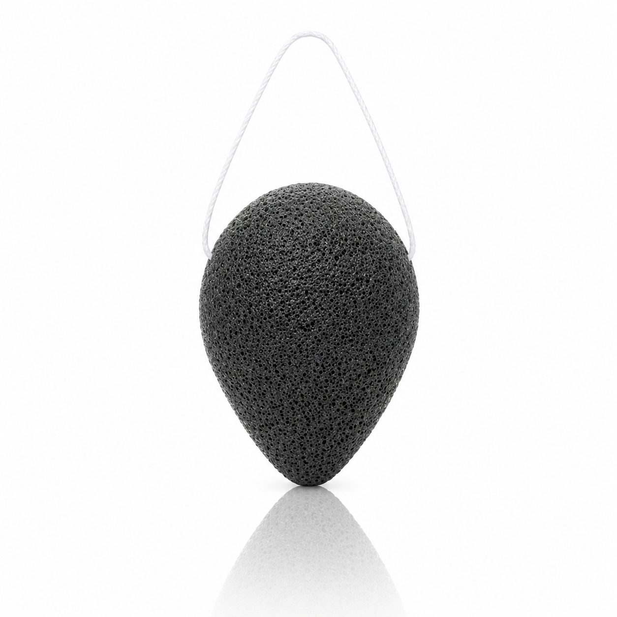 Purifying bamboo charcoal konjac sponge with a white hanging string on a clean white background.