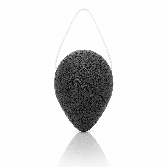 Purifying bamboo charcoal konjac sponge with a white hanging string on a clean white background.