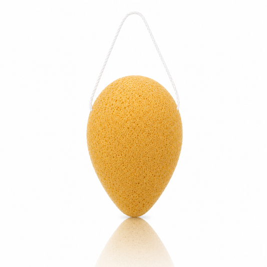 Turmeric konjac facial sponge with a white hanging string on a clean white background.