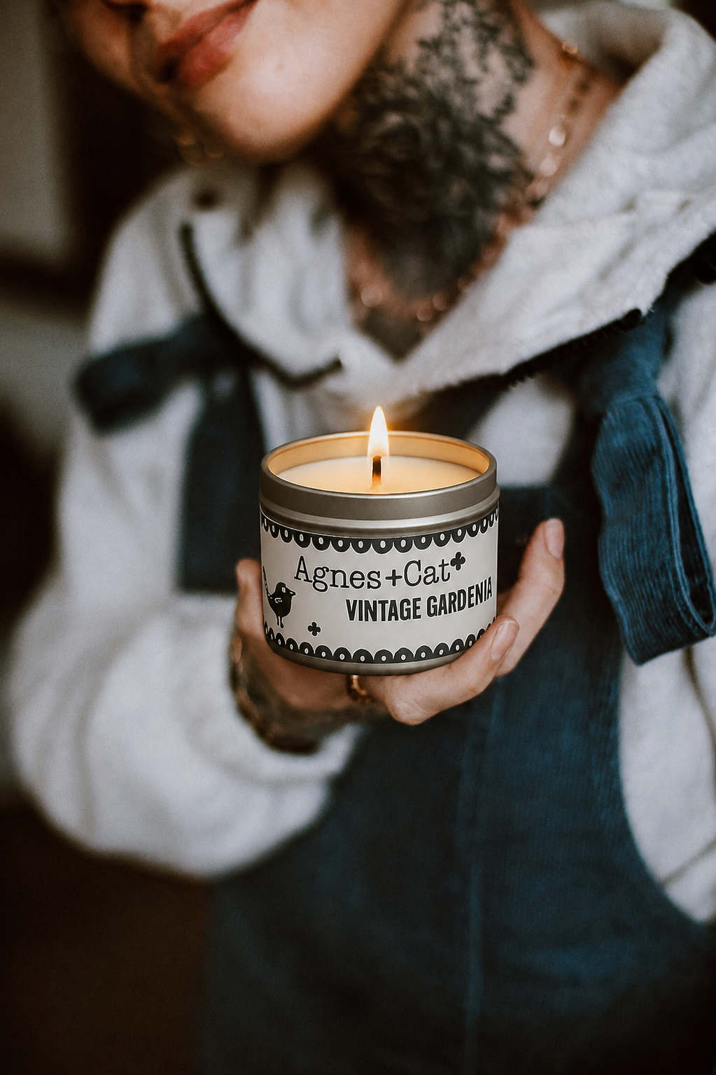 Lit Agnes + Cat Vintage Gardenia soy candle held in hand, creating a warm and cozy lifestyle atmosphere.
