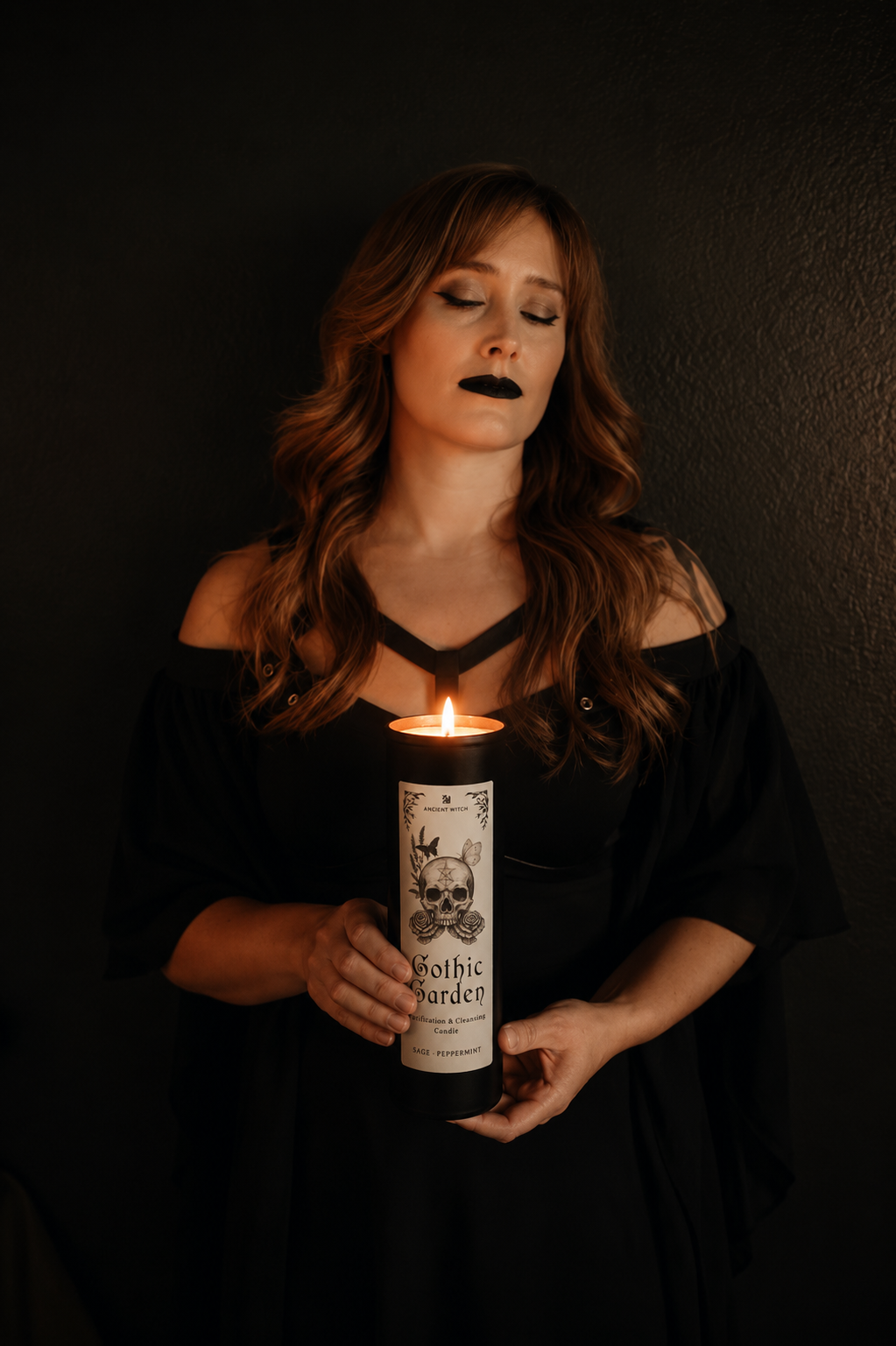 Woman holding a candle labeled 'Gothic Garden' against a dark background