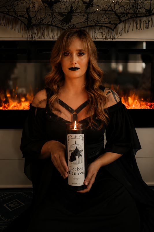 Woman holding a candle in front of a fireplace with decorative branches above.
