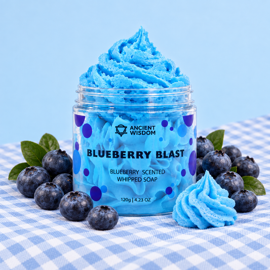 Open jar of Blueberry Blast Whipped Soap surrounded by fresh blueberries on blue gingham fabric against a soft pastel-blue background.