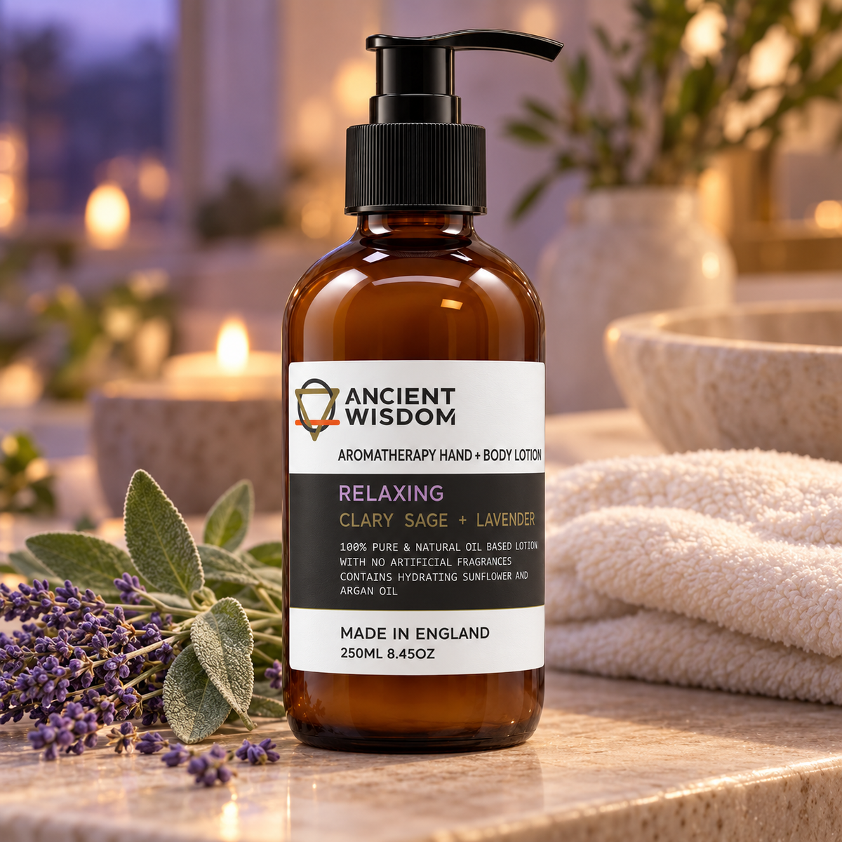 Ancient Wisdom Relaxing Hand & Body Lotion with Clary Sage and Lavender, displayed with lavender, sage leaves, soft towels and candlelight in a calming spa setting.