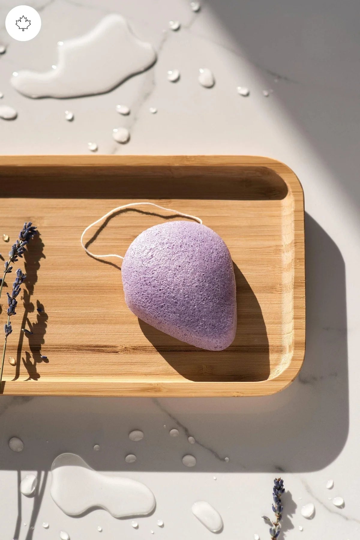Lumaysa Lavender Konjac facial sponge displayed on a wooden tray for a calming, natural skincare ritual