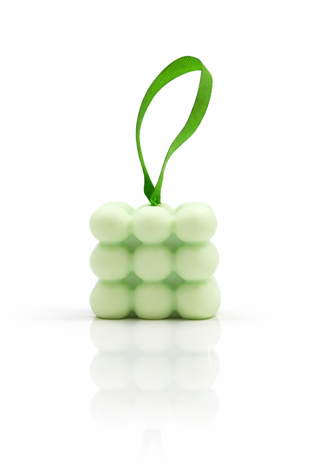 Lumaysa Peppermint & Eucalyptus massage bar with bubble texture and green hanging ribbon on a clean white background with soft reflection