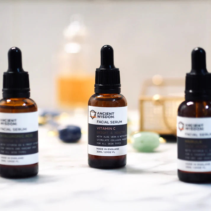 Three bottles of Ancient Wisdom facial serum on a blurred background