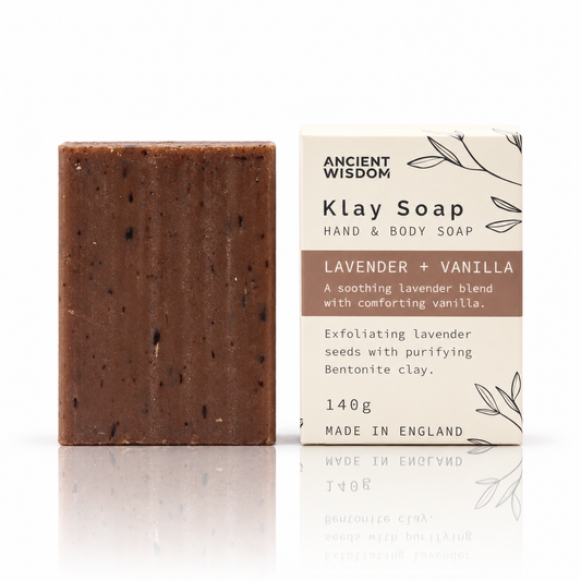 Lavender and vanilla Klay Soap bar beside its Ancient Wisdom packaging on a white background with a soft reflection.