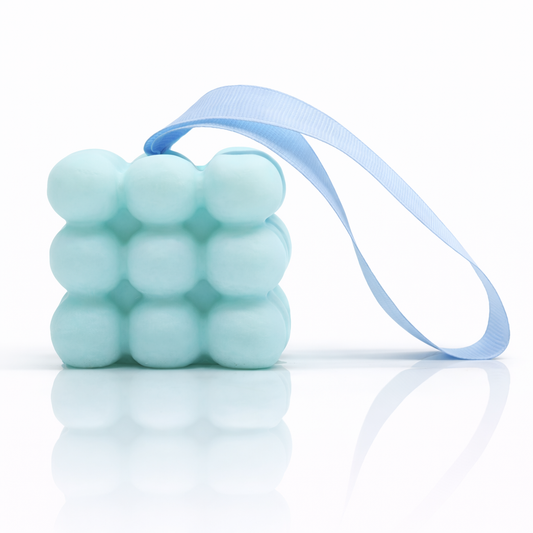 Blue bubble massage soap with ribbon on white background with strong reflection and premium clean skincare style