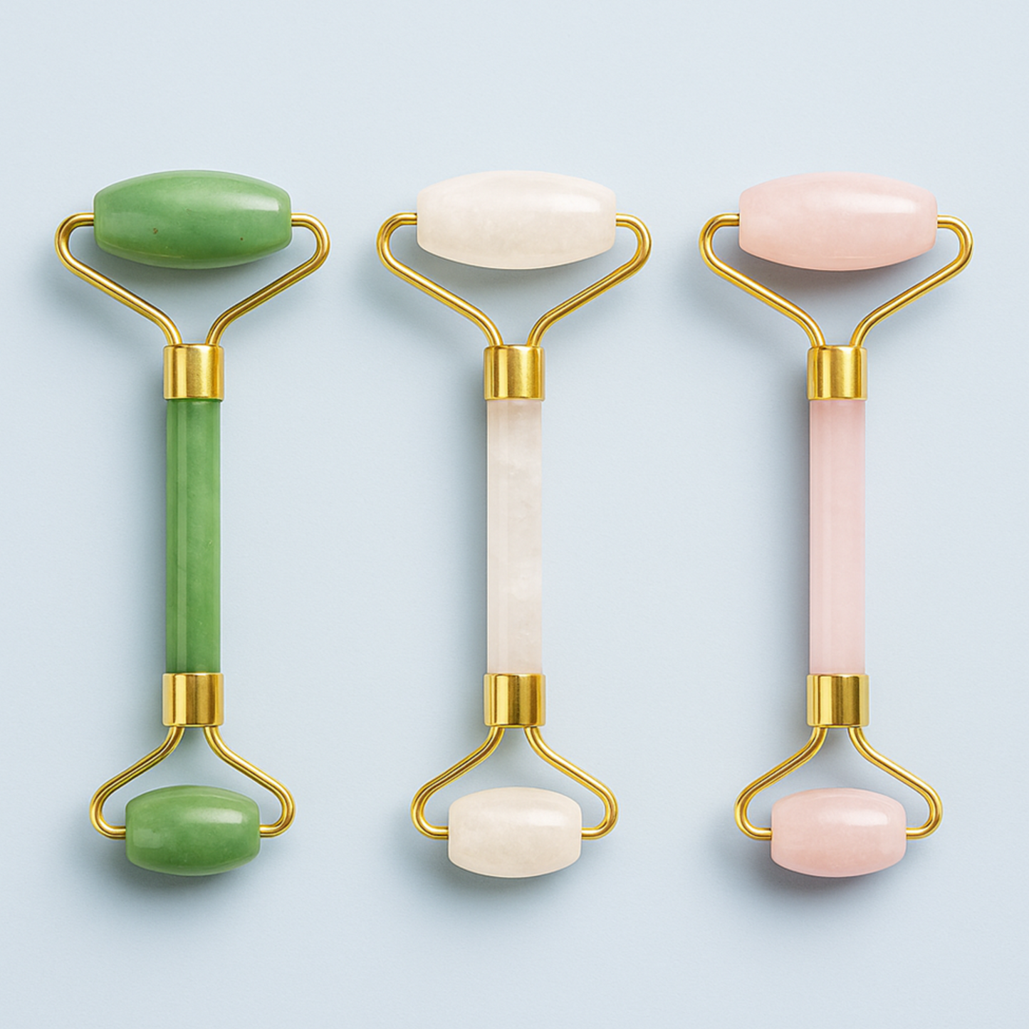 Lumaysa Gemstone Glow facial rollers in jade, clear quartz, and rose quartz with gold-toned brass frame on a soft neutral background
