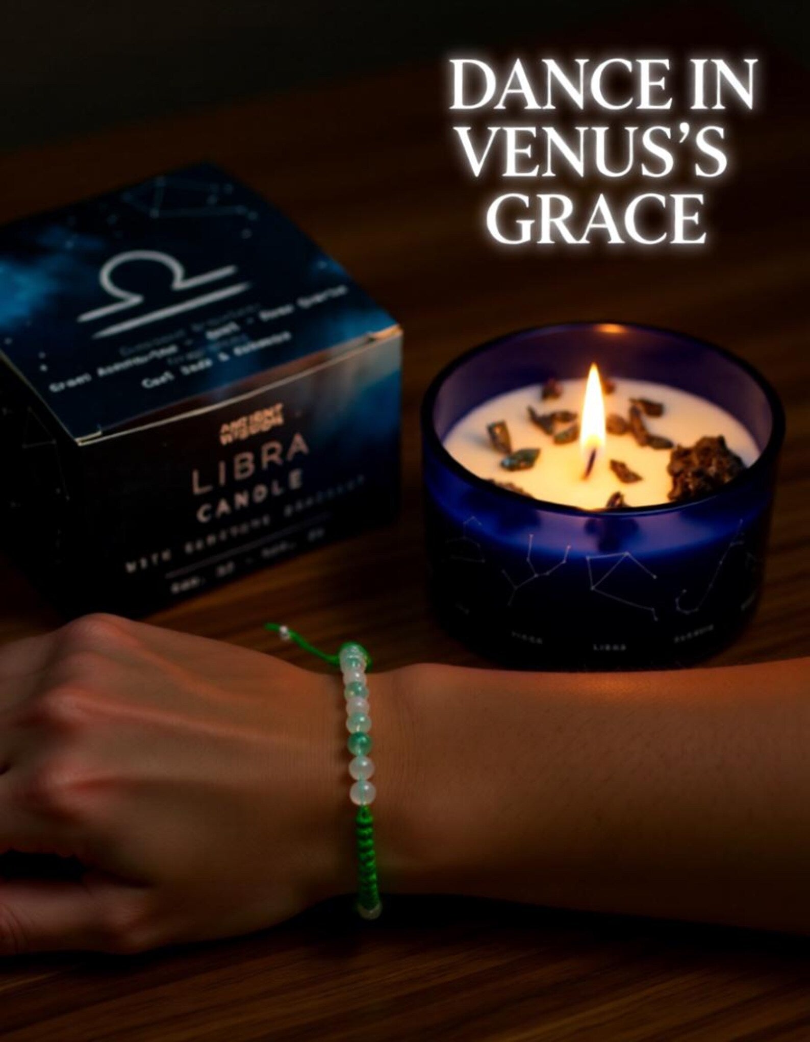 Libra zodiac harmony candle with matching box and a green gemstone bracelet worn on the wrist, featuring the text “Dance in Venus’s Grace” on a warm wooden surface.