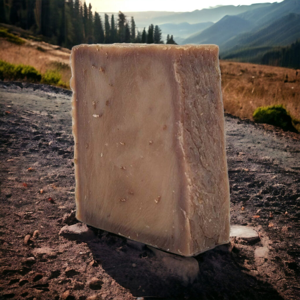 Natural Bar Soap – Lavender & Vanilla, beige bar standing on a rock with mountain landscape background.