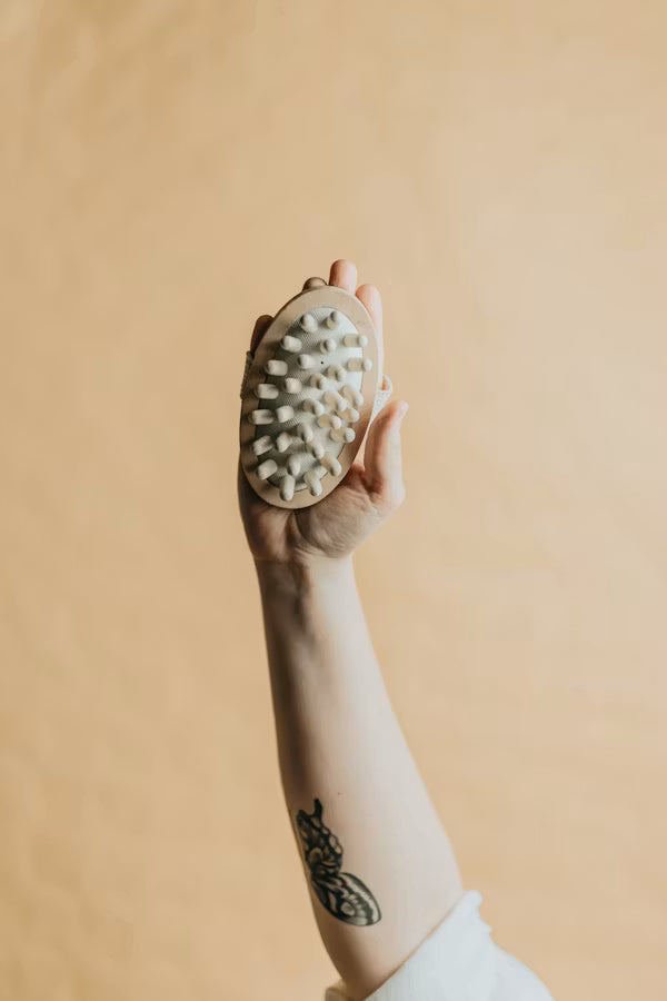 Hand holding a hairbrush against a beige background