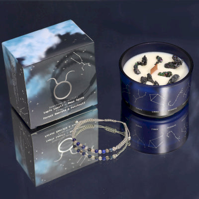 Lumaysa Taurus Zodiac soy candle with constellation glass jar, luxury gift box and gemstone bracelet on a reflective surface 